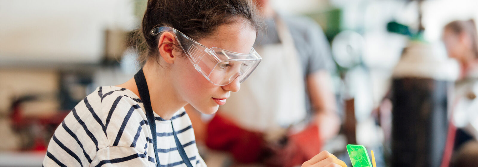 Girl wearing safety glasses doing soldering